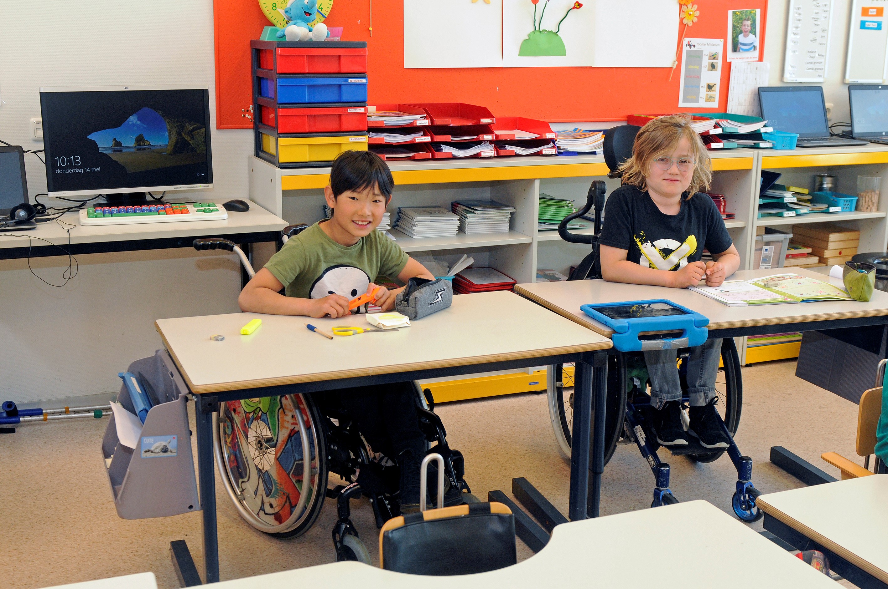 Twee kinderen in rolstoel in de klas.
